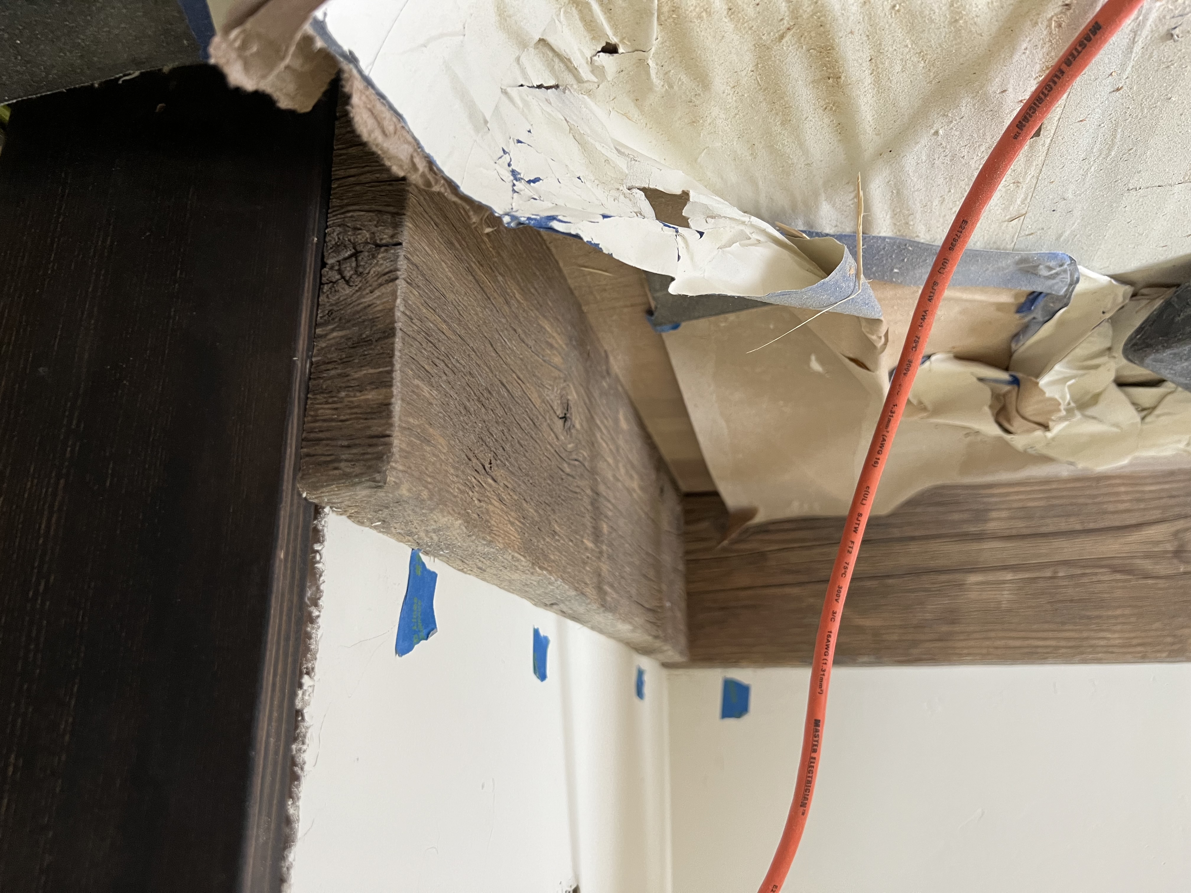 Close view of rustic wood trim installation near a doorway.